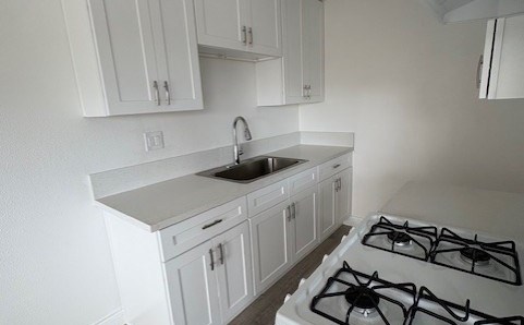 A white kitchen with a stove and cabinets.